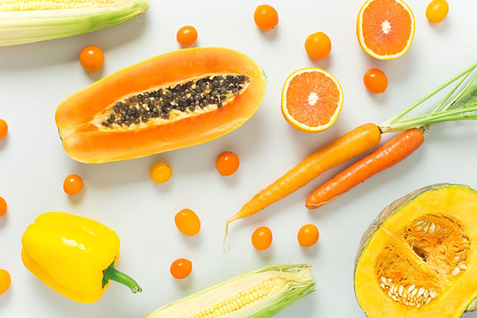 Cut up fruit and vegetables. Papaya,  grapefruit, carrot, corn, tomato and squash