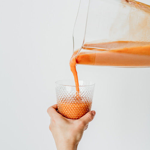 Juice being poured into a glass cup