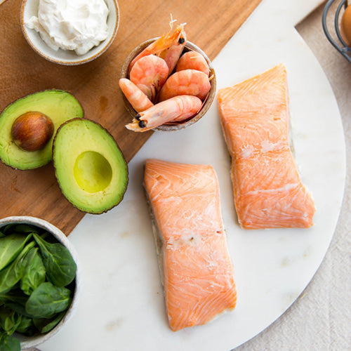 Healthy salmon dinner with shrimp, avocado and spinach