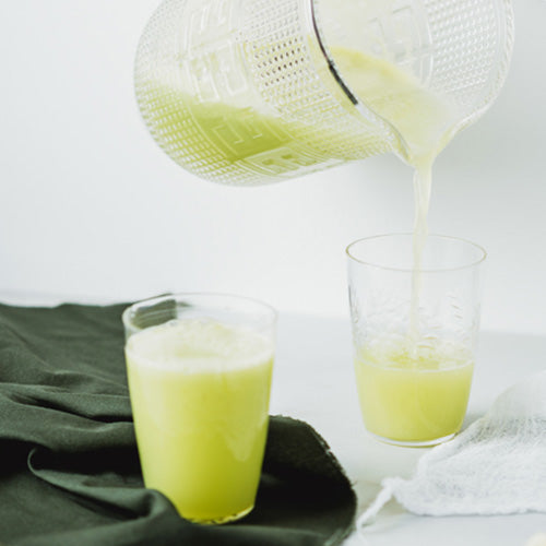 Green juice being poured into a glass