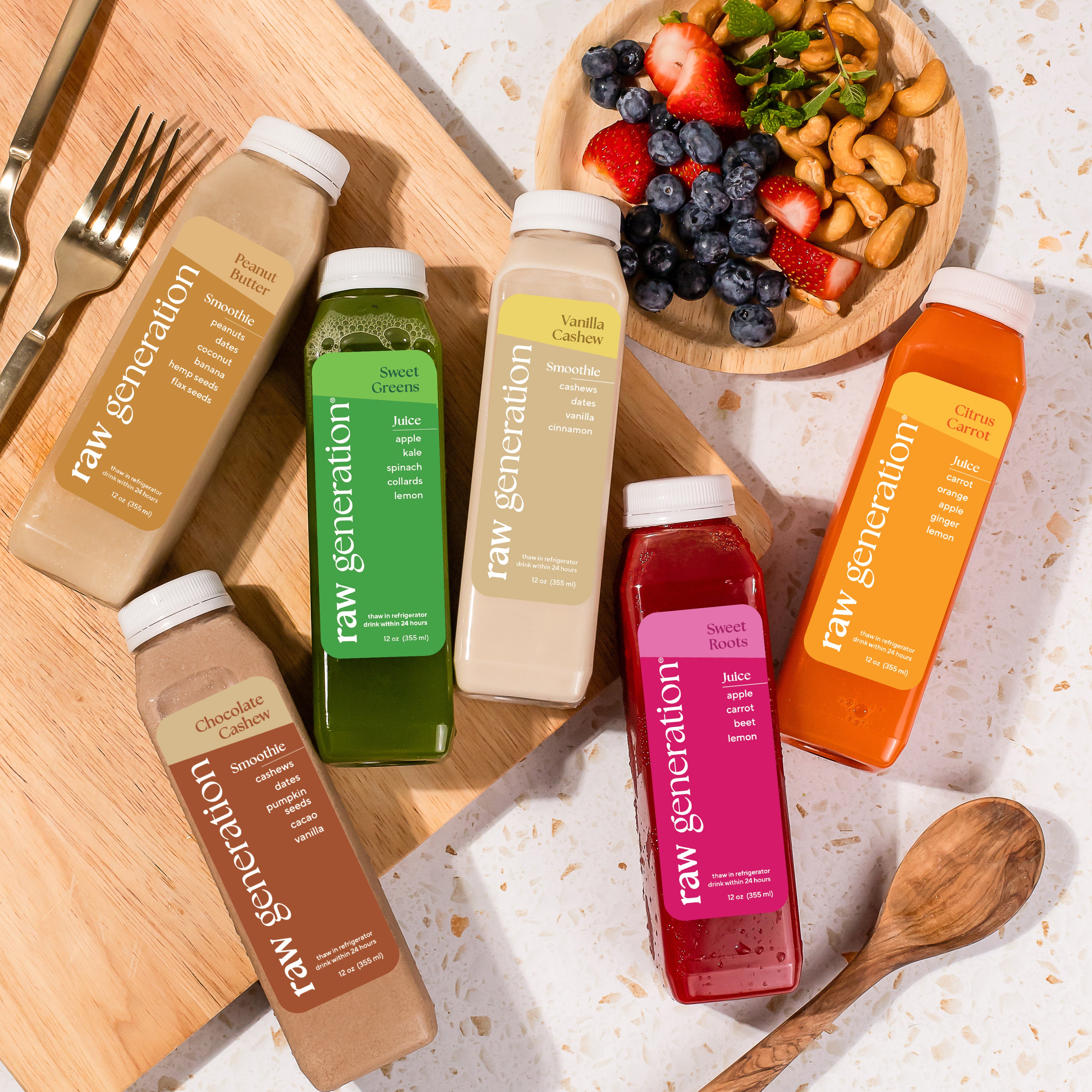 Protein Clease juices and smoothies on counter with fresh fruits and nuts