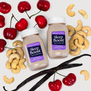 Sleep Boost™ (2-Count) bottles surrounded by nuts and cherries, showcasing a nutritionist-developed sleep aid with tart cherry juice and natural ingredients for restful sleep.