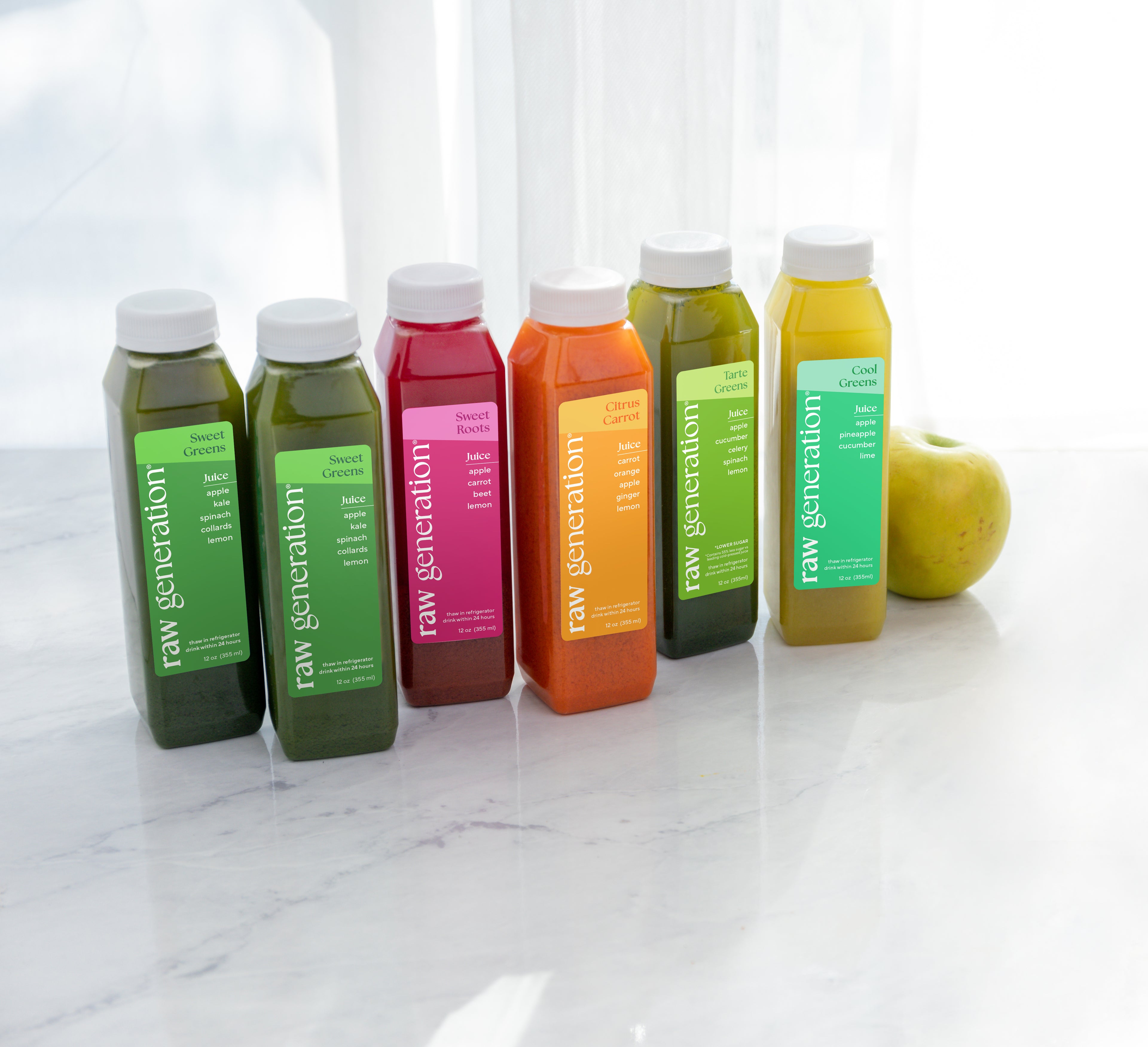 lineup of raw juices on a marble counter'