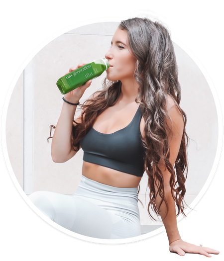 Woman in workout clothes drinking Raw Generation Sweet Greens juice