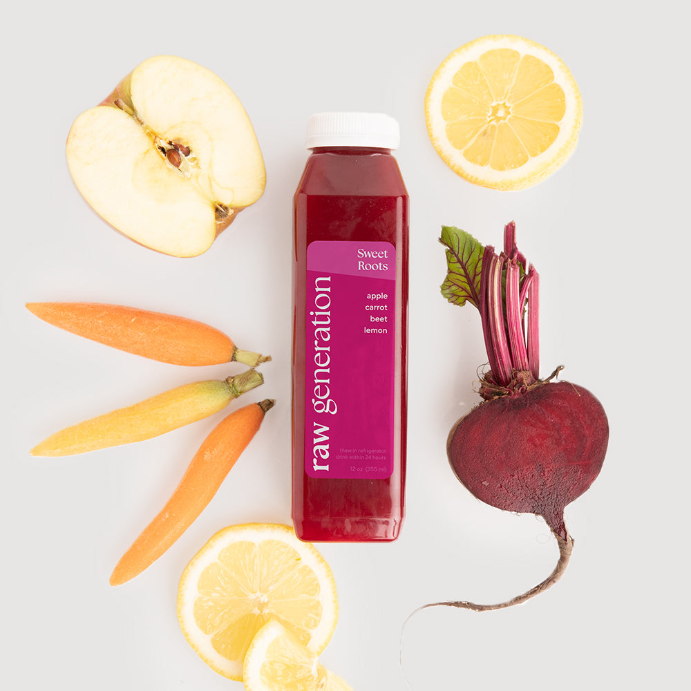 Sweet Roots Juice bottle surrounded by fresh ingredients: apples, carrots, beets, and lemon, showcasing the natural components of this nutrient-rich beverage.